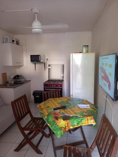 a kitchen with a table and two chairs and a refrigerator at Niky house in Fort-de-France