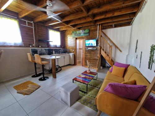 ein Wohnzimmer mit einem Sofa und einem Tisch in der Unterkunft Le Cosy Bungalow de Lili / 5min de l'aéroport in Les Abymes