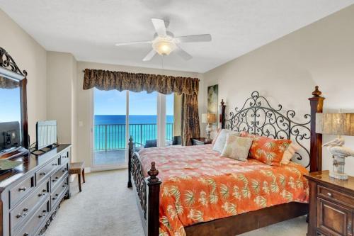 a bedroom with a bed and a view of the ocean at Treasure Island 707 - Gulf front, sunset views, heated resort pool & hot tub! in Panama City Beach