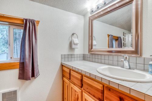 uma casa de banho com um lavatório e um espelho em Cozy Cabin em Rhododendron