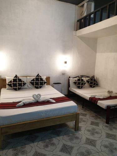 a bedroom with two beds with bows on them at Kwarto's in Siquijor