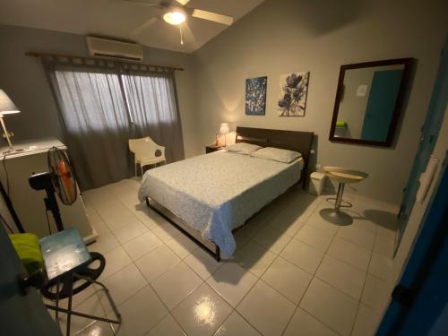 1 dormitorio con cama y espejo en Lugo`s guest room, en Punta Cana