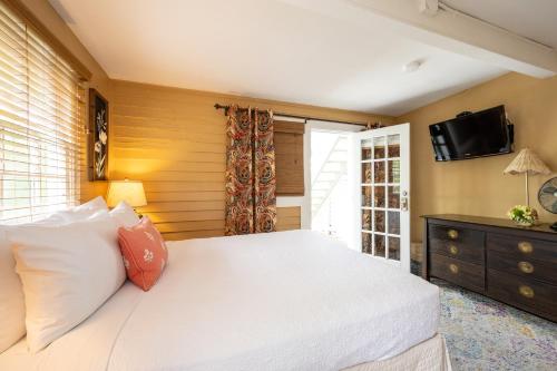 a bedroom with a white bed and a tv on the wall at Old Town Manor in Key West