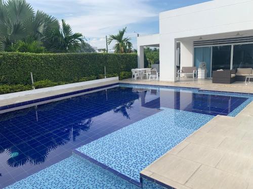 a swimming pool with blue tiles in a house at Casa Piscina Girardot Condominio Campestre in Flandes