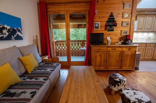 uma sala de estar com um sofá e uma árvore de Natal em Bergerie 3 Vallée Centaurée 20 em Les Allues