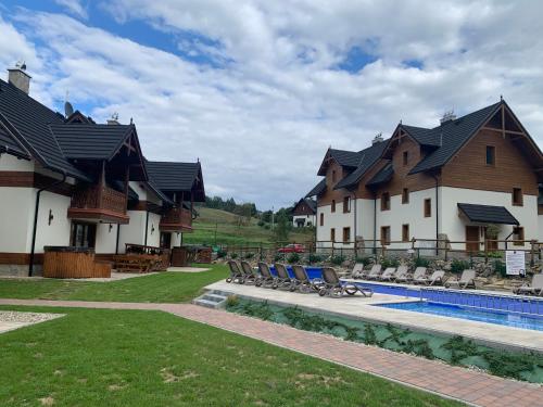 a house with a swimming pool next to a resort at Maison de Pieniny in Jaworki