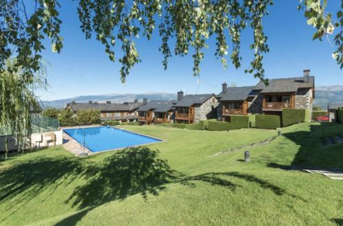 un grand jardin avec une piscine et des maisons dans l'établissement Chalet à Nahuja, à Nahuja