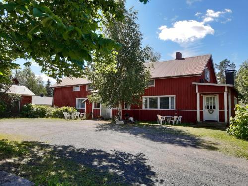 a red barn with tables and chairs in front of it at Yö Kotikoivun rauhassa in Kankaanpää