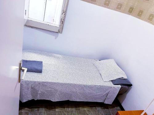ein weißes Schlafzimmer mit einem Bett und einem Fenster in der Unterkunft Barcelona Centric in Barcelona