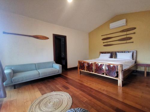 a bedroom with a bed and a couch in it at Gatun Lake Lodge Hotel in Pueblo Nuevo