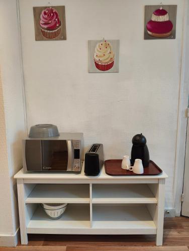 a microwave on top of a table with cupcakes at Avranches - gare- Mont Saint-Michel in Avranches