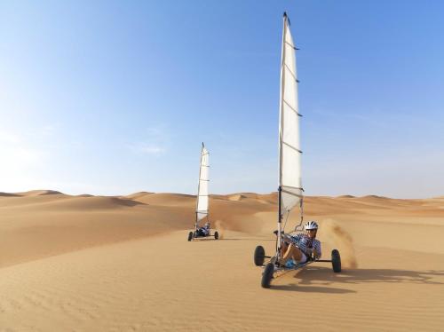 a person riding a buggy in the desert at Anantara Qasr al Sarab Desert Resort in Jurayrah