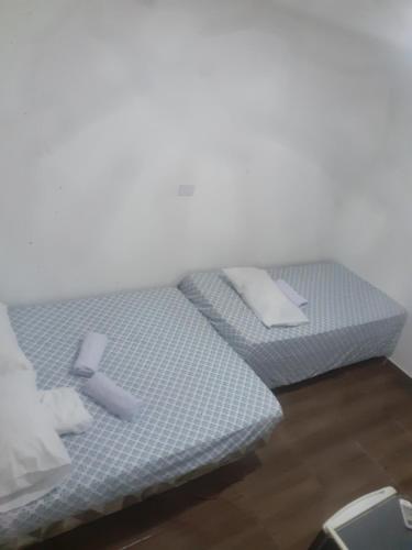 two beds sitting next to each other on a wooden floor at Hospedagem da barra suites,praia barra grande,caminho de moises e antunes in Maragogi