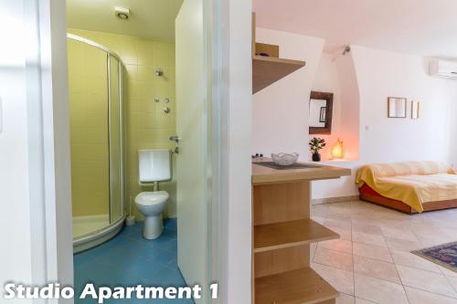 a bathroom with a shower and a toilet and a bed at Art Apartments Vrsar in Vrsar