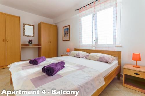a bedroom with a large bed with purple pillows on it at Art Apartments Vrsar in Vrsar