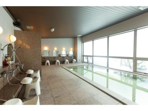 una piscina in un edificio con una grande finestra di ＨＯＴＥＬ ＴＲＵＮＫ ＷＡＫＫＡＮＡＩ - Vacation STAY 92551v a Wakkanai