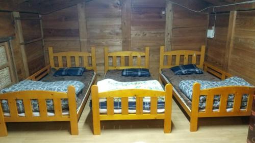 three beds in a room with wooden walls at Kura "Ika" - Vacation STAY 95263v in Nagahama