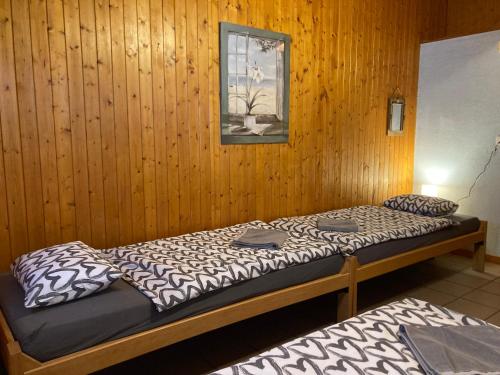 two beds in a room with wood paneled walls at B&B Chalet Rey-Bellet in Les Crosets