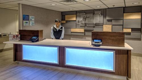 a man is standing behind a counter in a store at Holiday Inn Express Memphis Medical Center - Midtown by IHG in Memphis