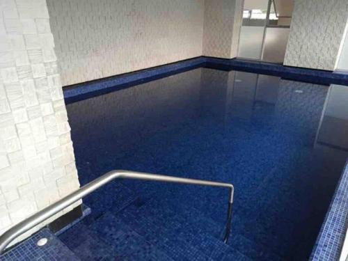 una piscina con suelo azul y pasamanos de metal en QUO 601 Lujo Confort Seguridad, en Guayaquil