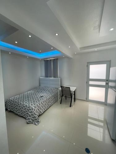 a bedroom with a bed and a table and a window at 1058 Modern Apt 7 in San Juan