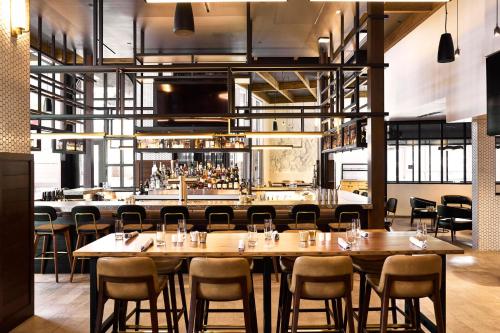 a restaurant with tables and chairs and a bar at Archer Hotel Tysons in Tysons Corner