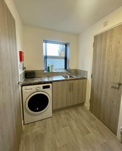 a kitchen with a sink and a washing machine at 5. Homely Cecil Apartments in Birmingham