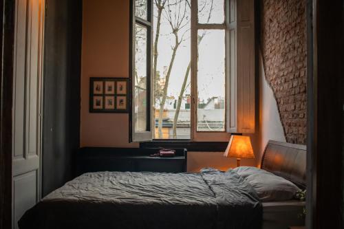 a bedroom with a bed and a window at Casa Mutante Hostel in Montevideo