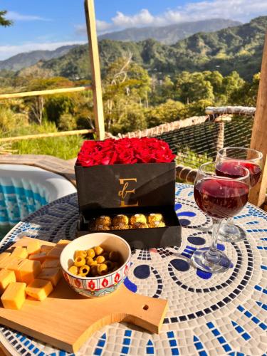 a table with a box of roses and a glass of wine at Finca Ecoparaiso in Ibagué