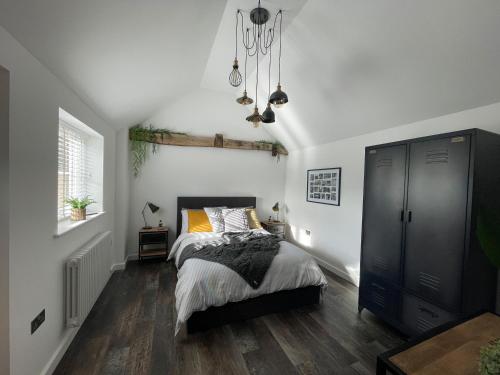 1 dormitorio con cama y lámpara de araña en The Old Brewhouse & Piggery, en Newport