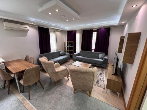 ein Wohnzimmer mit einem Sofa, Stühlen und einem Tisch in der Unterkunft Şişli taksimde 2 Bedrooms and sitting room D 3 in Istanbul