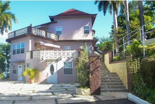 a large white house with stairs in front of it at Bella Vista Vacation in Montego Bay