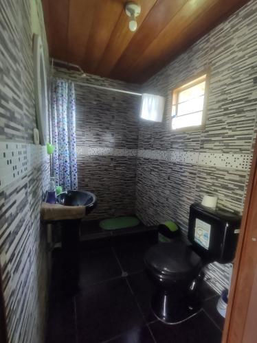 ein kleines Bad mit WC und Waschbecken in der Unterkunft Quirquincho House in Puerto Maldonado