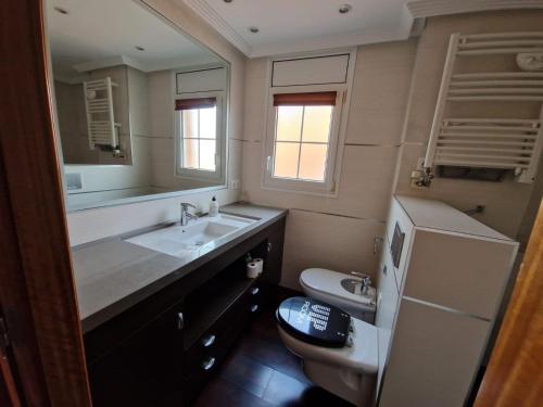 bagno con lavandino, servizi igienici e specchio di Cal Vals a Figueres