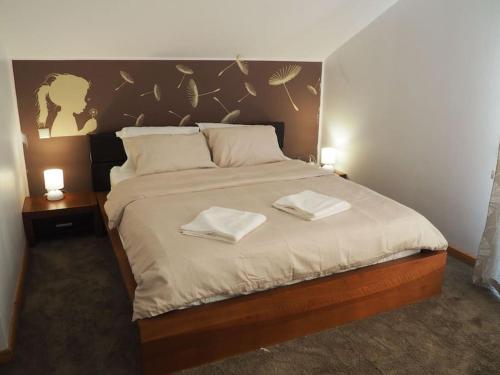 een slaapkamer met een groot bed en 2 handdoeken bij Modern 3 bedroom house with a private pool in Popeşti-Leordeni