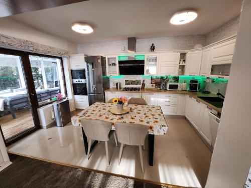 een keuken met een tafel en stoelen. bij Modern 3 bedroom house with a private pool in Popeşti-Leordeni