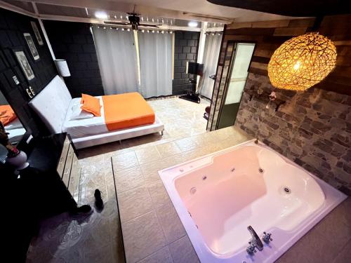 a bathroom with a tub and a bedroom with a bed at Finca Campestre Villa del Campo in Santa Rosa de Cabal