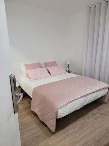 um quarto com uma cama grande e almofadas cor-de-rosa em Alojamento Local Vitoria em Batalha