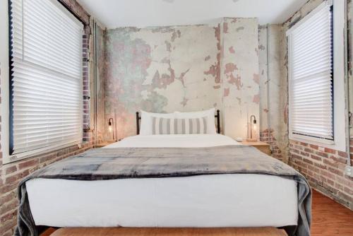 a bedroom with a large bed and two windows at Historic Place in Downtown in Memphis