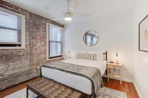 a bedroom with a bed and a brick wall at Super Central Location in Memphis