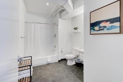 Un baño blanco con inodoro y ducha. en Super Central Location Historic but Modern, en Memphis