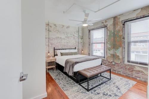 a bedroom with a bed and a brick wall at Historic South Main Gem in Memphis