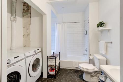 a white bathroom with a washing machine in it at Right on Main St with Historic Vibe! in Memphis
