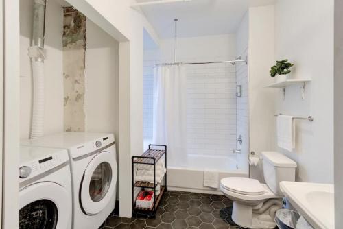 a white bathroom with a washing machine in it at Historic Vibe on Main St in Memphis