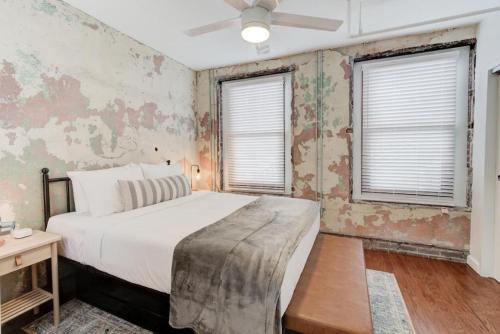 a bedroom with a bed and two windows at Historic Revival Downtown in Memphis