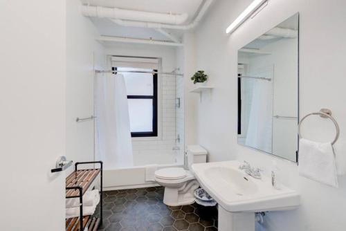 a white bathroom with a sink and a toilet at Historic Revival Downtown in Memphis