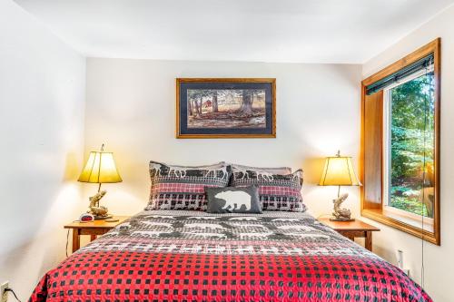a bedroom with a red bed with two lamps at Eagle's Nest on Lake Sutherland in Port Angeles