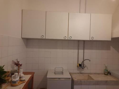a kitchen with white cabinets and a sink at Casa da Tia Lena in Coimbra