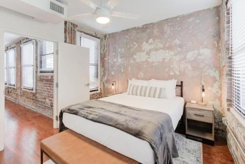 een slaapkamer met een bed en een bakstenen muur bij Historic Apartment in Prime Location in Memphis