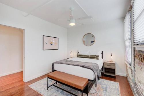 Habitación blanca con cama y espejo en Revitalized Historic Place en Memphis
